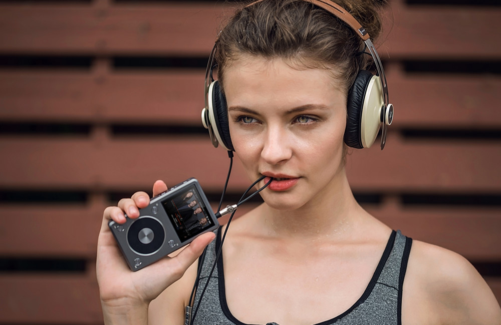 Listen player. FIIO x5 2. Девушка с плеером. Человек с плеером. Девушка слушает плеер.